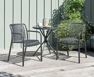 Cafébord og to stole i grå på terrasse