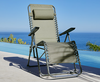 Relaxstol i grøn på terrasse ved pool