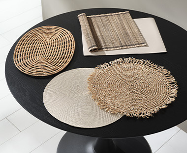 Rundt spisebord med runde dækkeservietter, oval dækkeserviet og firkantede dækkeservietter