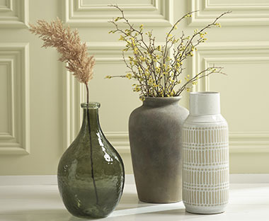 Grøn glasvase, grå/brun gulvvase og hvid vase på gulv