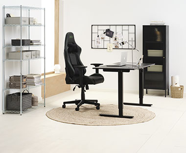 Gamingstol og sort hæve-sænke-bord i kontor