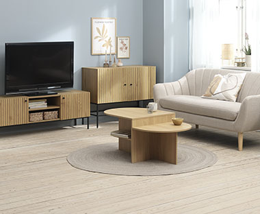 Sofabord med hylder, beige sofa, skænk og TV-bord i stue