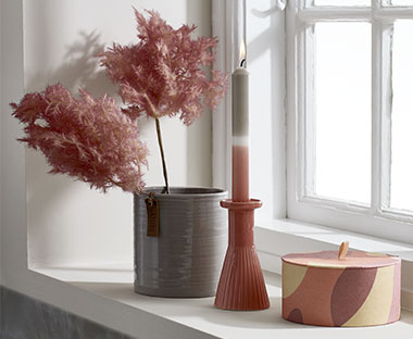 Blomsterpotte, lysstage og dekorativ boks i vindueskarm