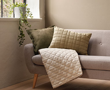 Sofa med rygpude, pyntepude og vattæppe 