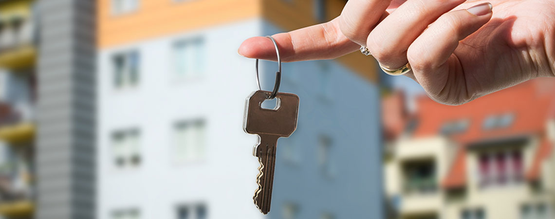 Kvinde holder en nøgle til et sommerhus eller hjem der udlejes