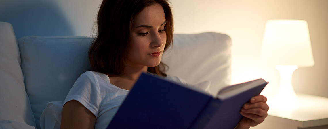 Kvinder der læser en bog i sengen