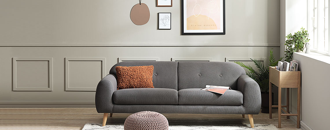 Stue med sofa, billedvæg og puf 