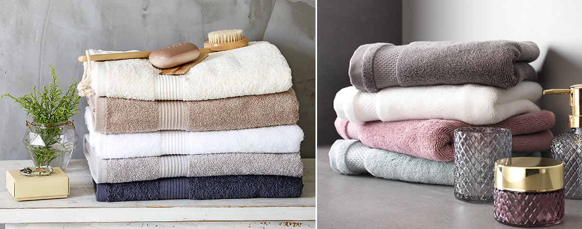 2 stakke af håndklæder og badehåndklæder i forskellige farver på badeværelse