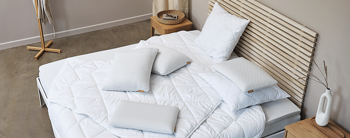 Soveværelse med seng, madras, topmadras, dyner og puder i skandinavisk design