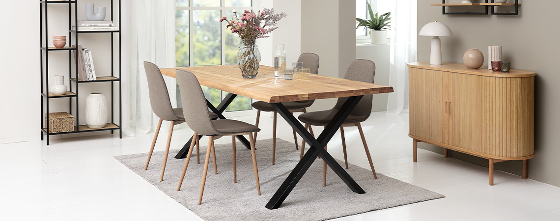 Spisestue med spisebord og fire grå spisebordsstole med ben i træ