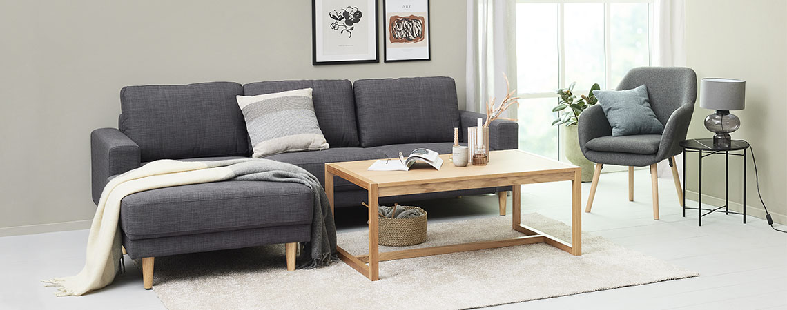 Stue med sofa, sofabord og lænestol og tæppe med høj luv på gulvet