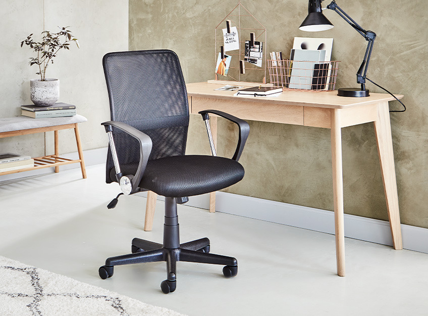 Skrivebord i eg og sort kontorstol i et stilfuldt rum