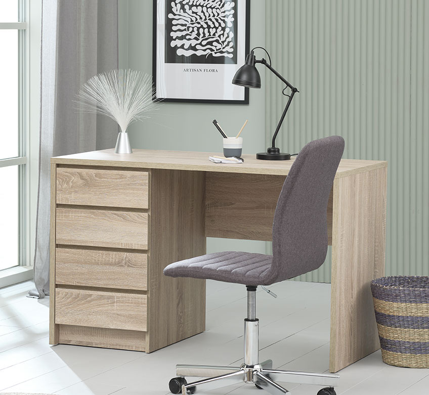 Skrivebord med bordlampe, kontorstol og papirkurv på kontor
