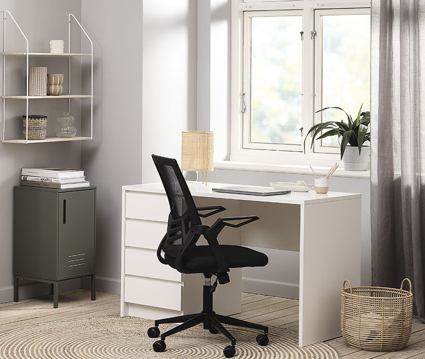 Hvidt skrivebord med bordlampe, kontorstol og papirkurv på kontoret