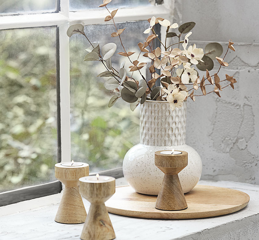 Lys beige eller hvid vase med mønster, kunstige blomster og fyrfadsstage i træ 