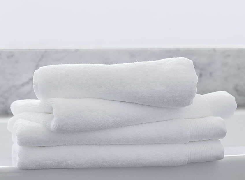 Hvide håndklæder i en stak i et badeværelse