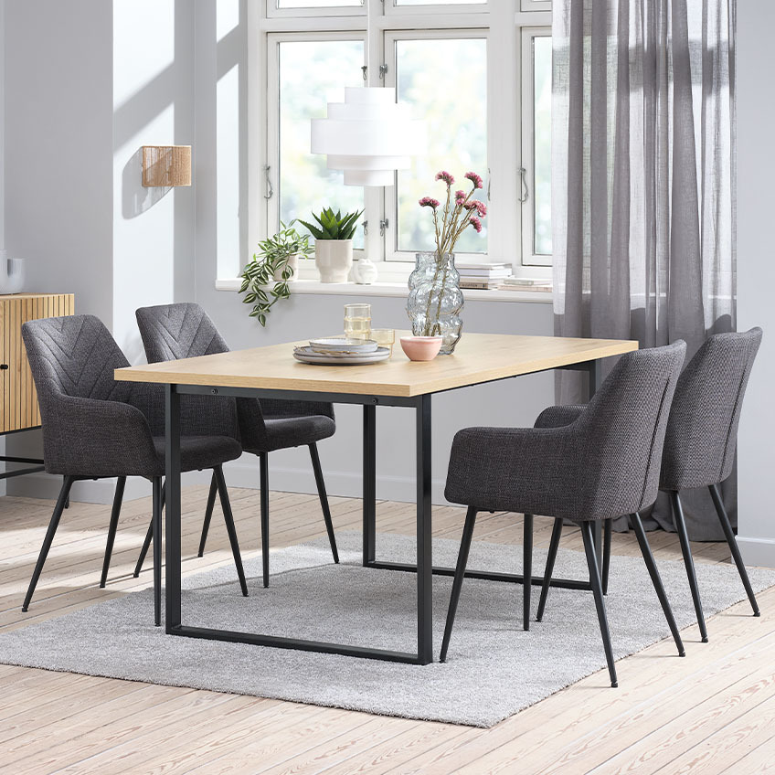 Fire spisebordsstole i grå velour om et spisebord 