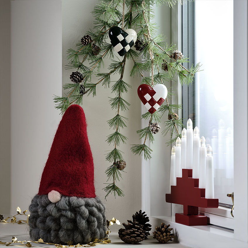 Julenisse med rød nissehue og gråt skæg, svensk lysestage   