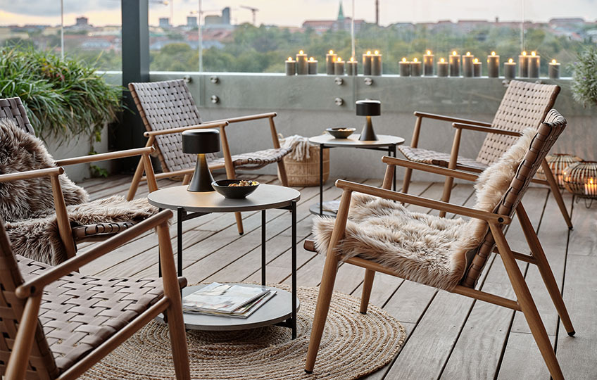 Lille havebord med overflader af fibercement og loungestole på terrasse