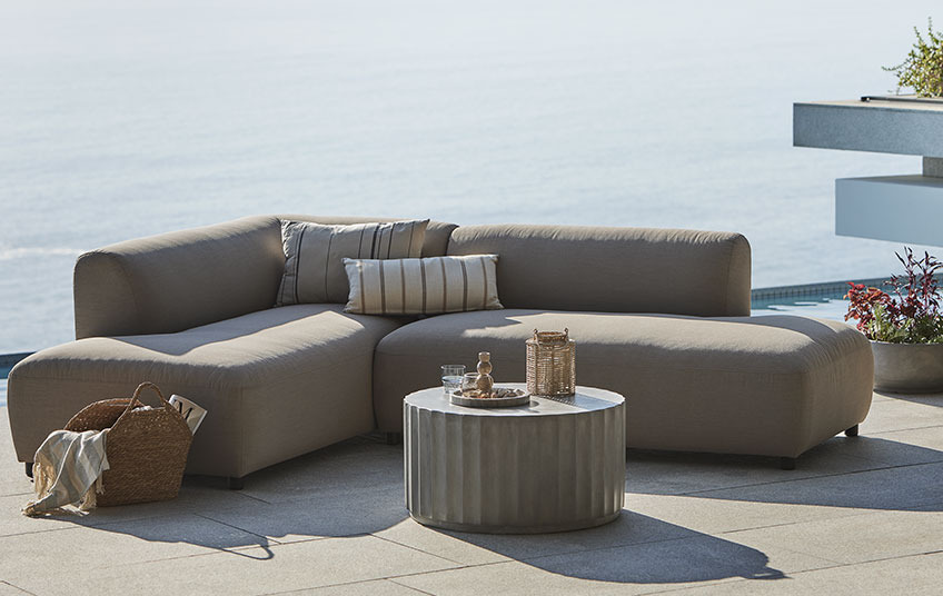 All-weather lounge sofa i beige og loungebord på en altan 