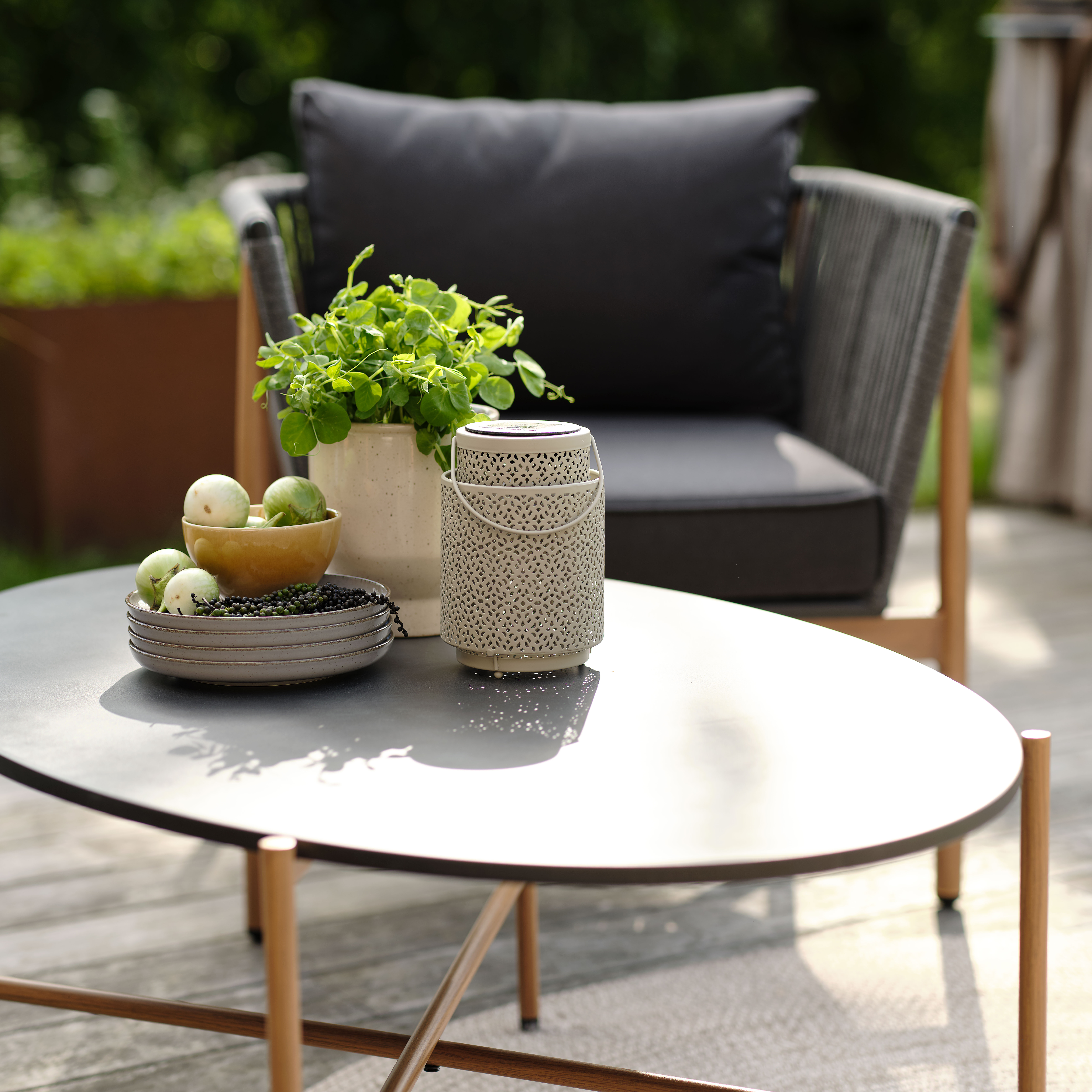 Loungebord med lanterne and krukke på en terrasse