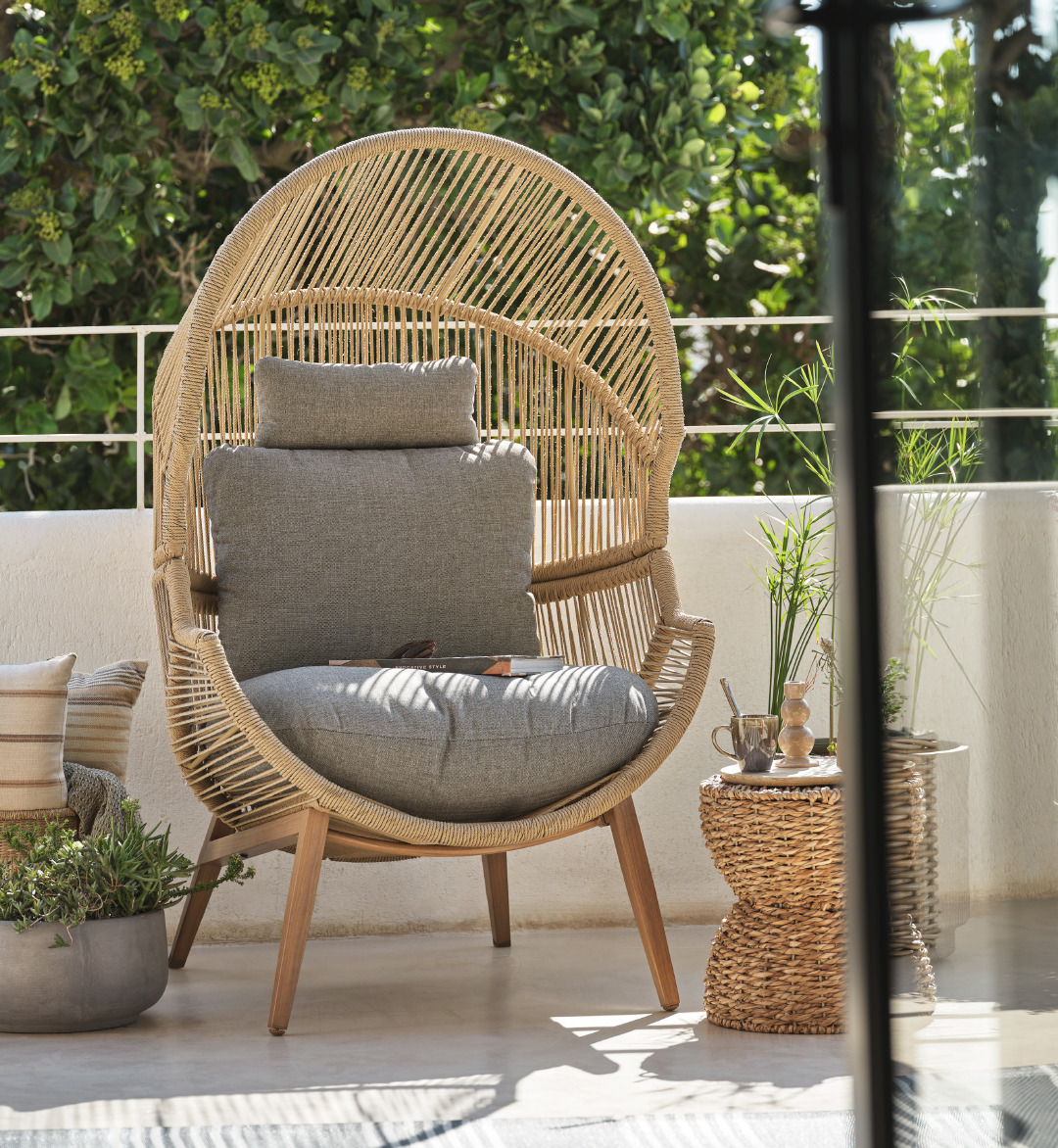 Hyggekrog på terrassen med loungestol HALVREBENE, planter i havekrukker og kaffe på piedestal PILFINK