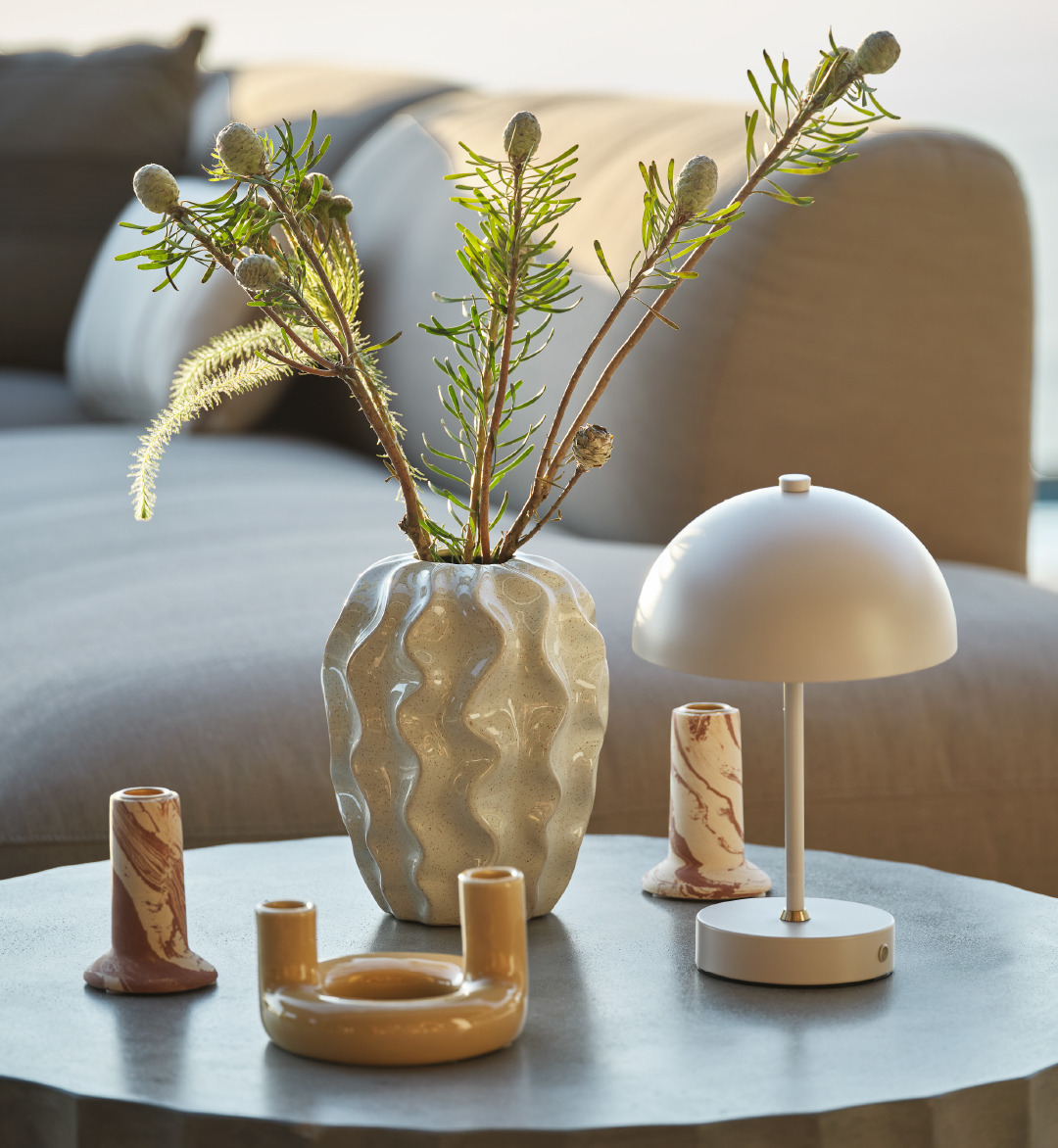 Smukt stylet loungebord med lysestager, vaser og lampe