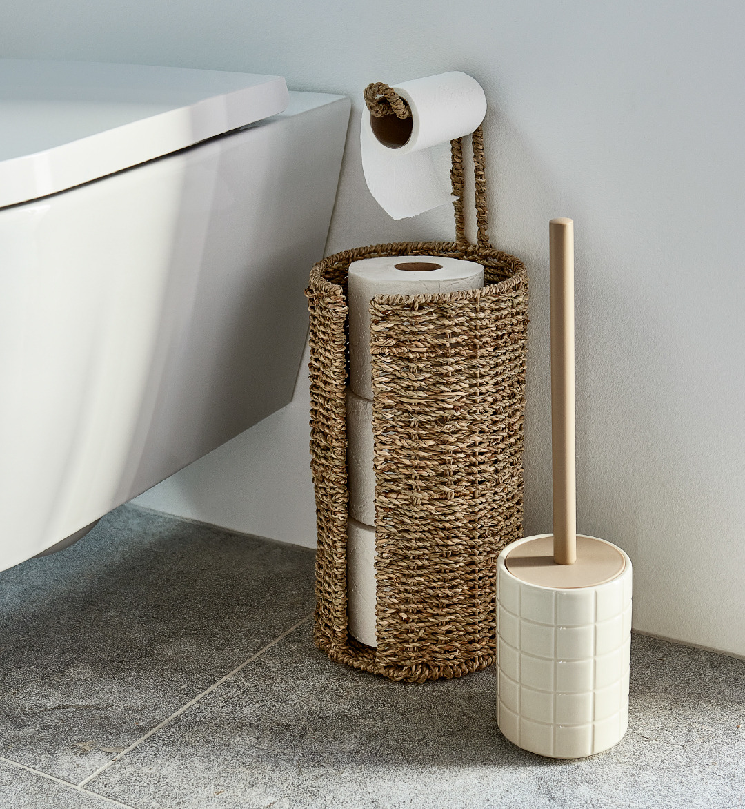 Toiletbørste STENINGE i beige og toiletrulleholder VANSBRO på stenfliser ved siden af toilettet