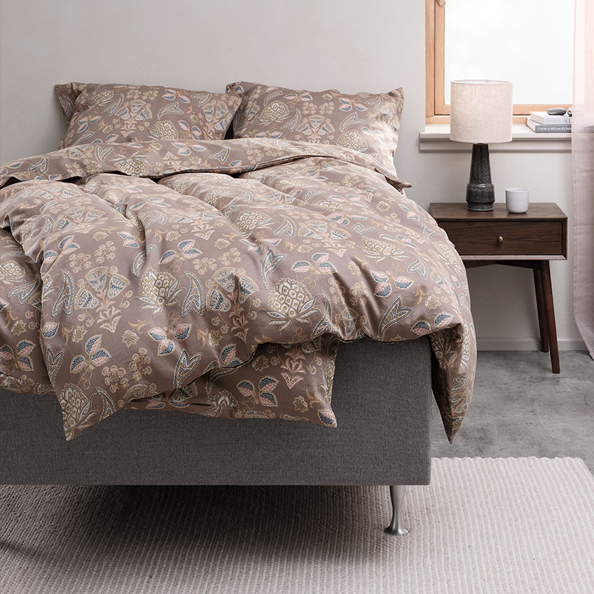 Sengesæt og bomuldssengetøj med paisleymønster på seng i soveværelse  