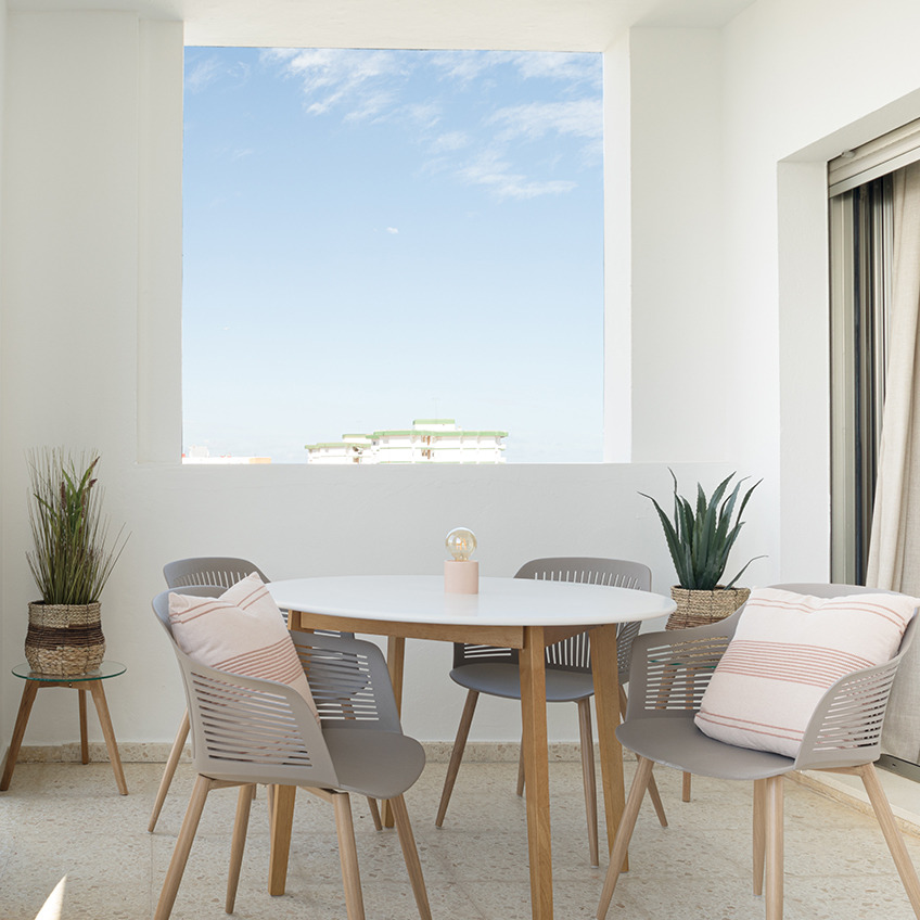 VANTORE havestol, JEGIND spisebord, FALSLED borde, NATTLILJA pude, ARNOLD batterilampe, CELIUS falsk plante og GODSKE falsk plante. Møbleret terrasse med bord, stole og dekorationer.