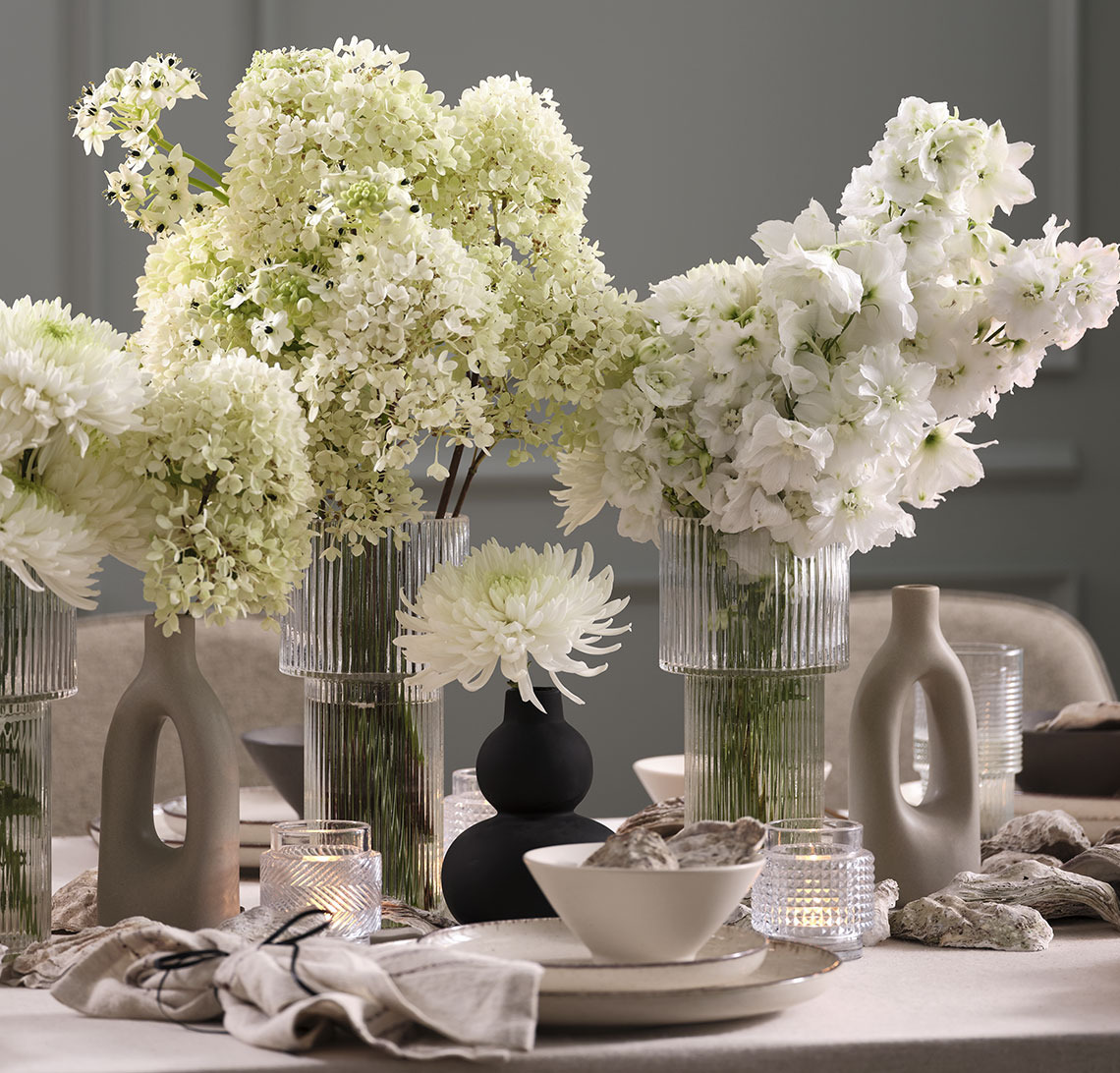 Sort vase og glasvaser med blomster på nytårsbordet