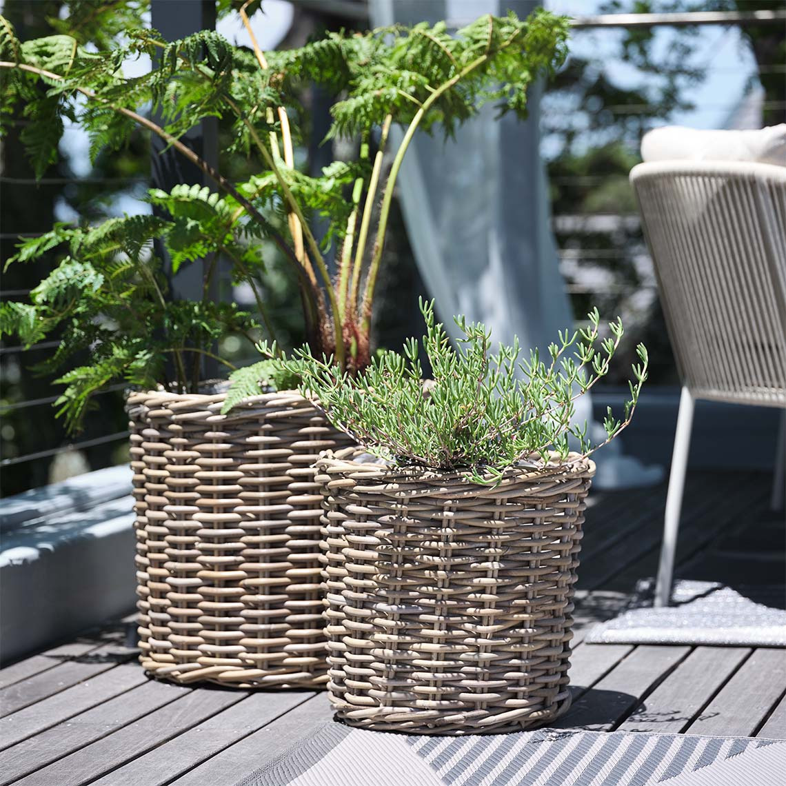 SEGLA havekrukker i flettet rattan Havekrukker i flettet rattan med planter på terrasse