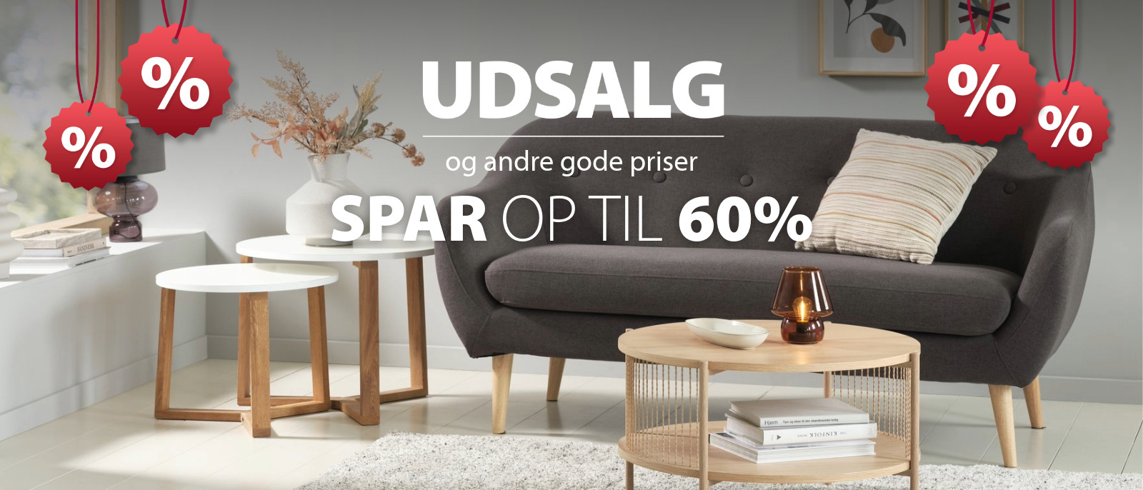 Stue med mørkegrå stofsofa og tre lyse sofaborde