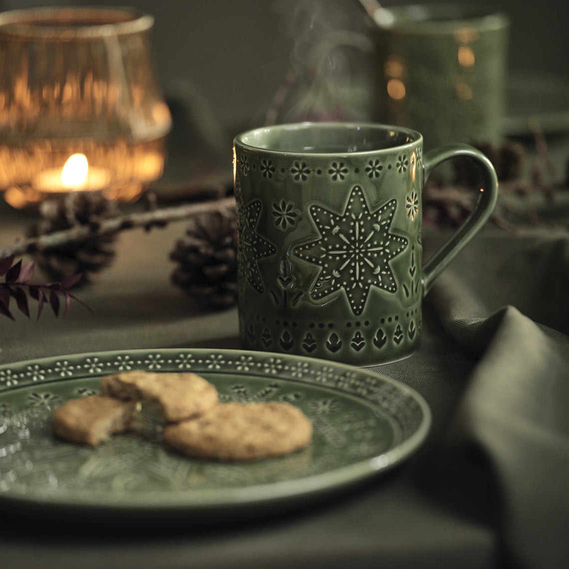 Grøn juletallerken og krus på et julebord