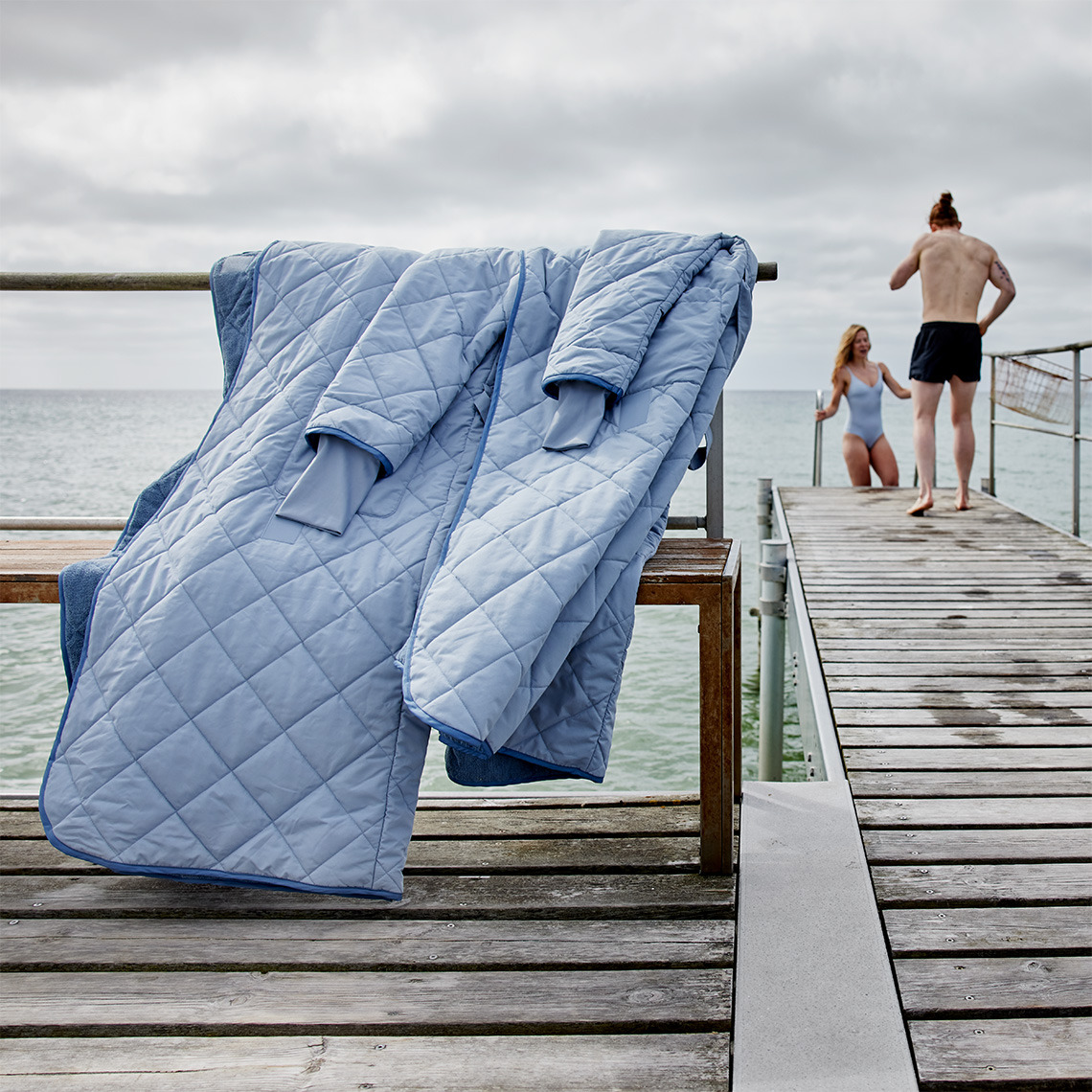 OSBY er varm, vindtæt, absorberende og tørrer hurtigt To personer vinterbader på en kold dag med vinterbadekåber i forgrunden
