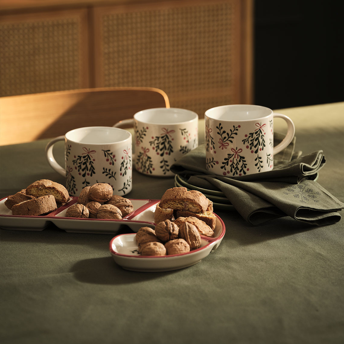 Julekrus, -skål og julestofservietter på et bord