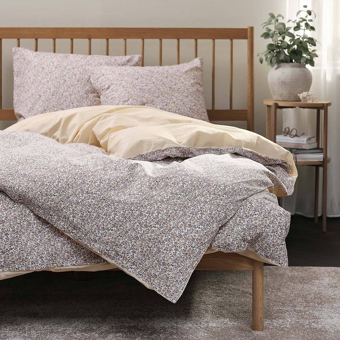 Sengetøj med blomstermønster i bløde lilla og gule farver