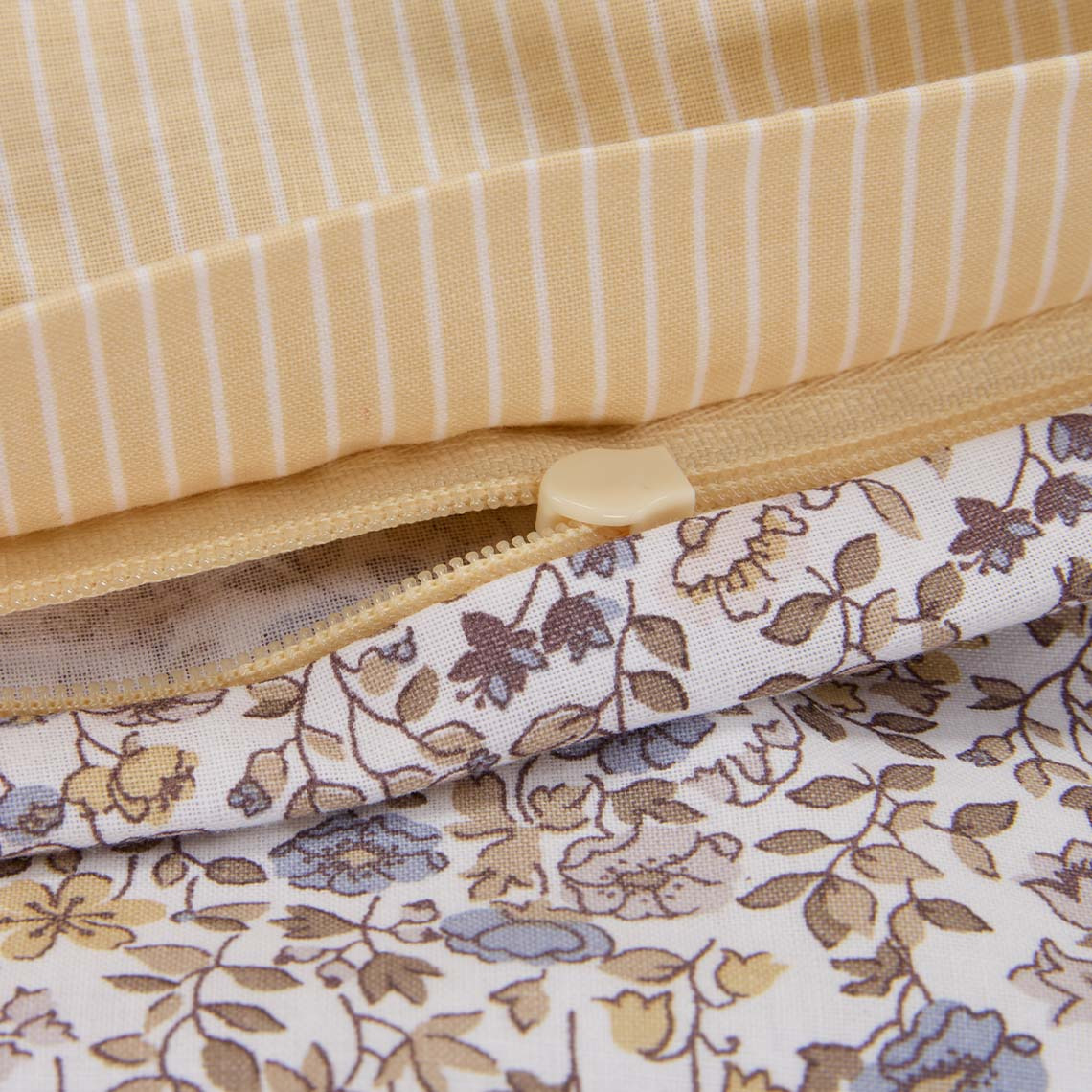 Bomuldssengetøj med små pastelblomster i lilla og gule nuancer