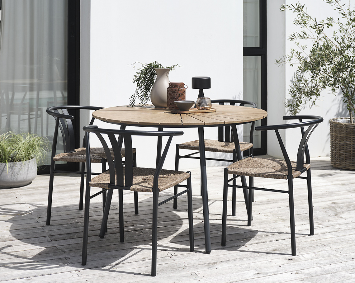Rundt havebord med fire havestole på en terrasse