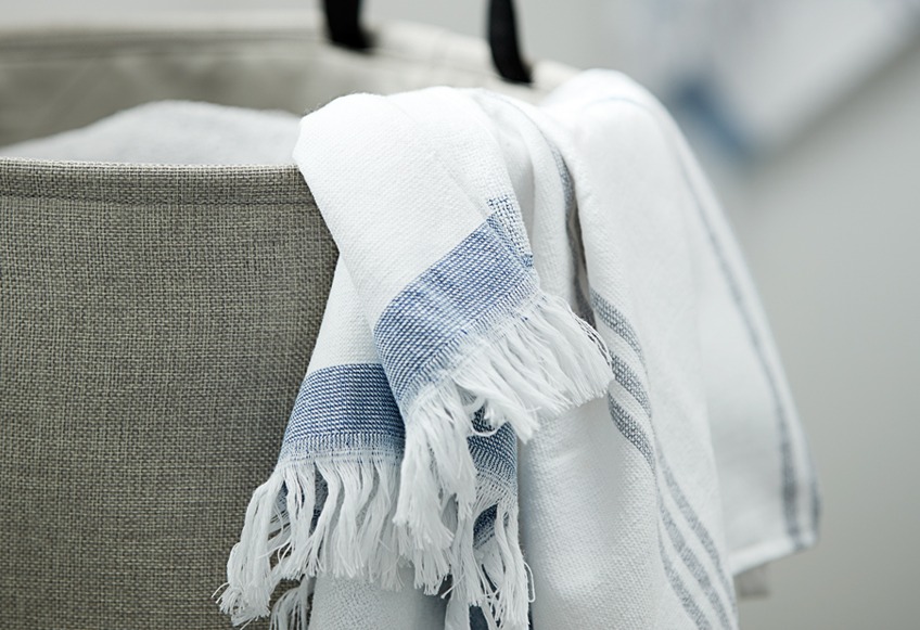 Vasketøjskurv med håndklæde i hvidt og blåt