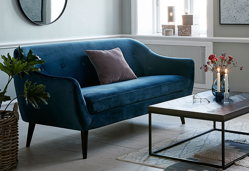Stue med blå sofa midt i rummet