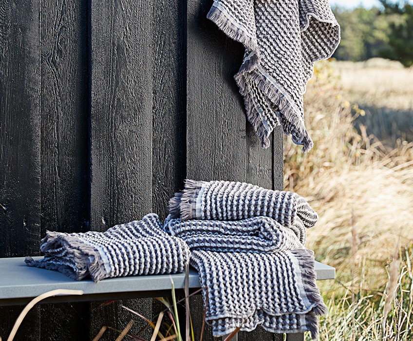 Håndklæder på en bænk ved et træhus