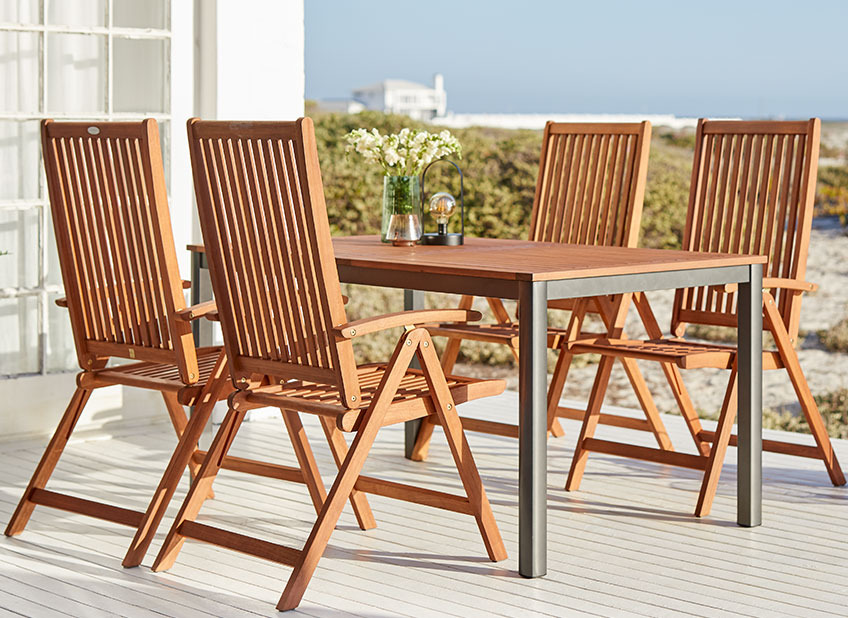 YTTRUP havebord i træ og KAMSTRUP positionsstole Havebord i træ og havestole på en terrasse ved havet