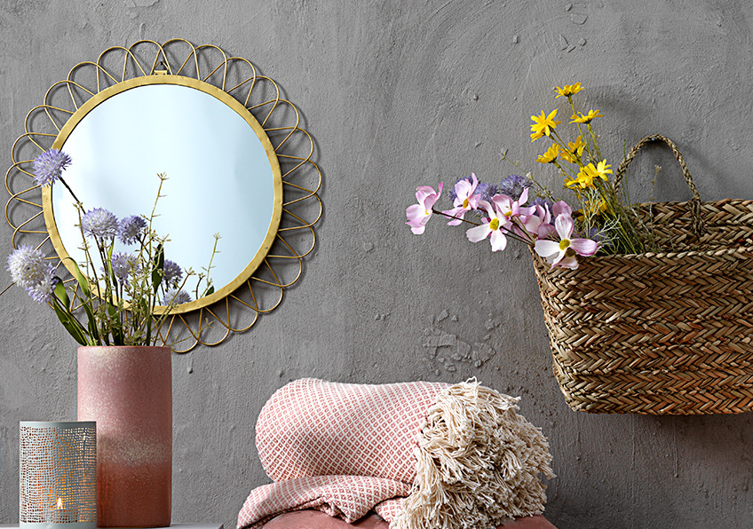 Spejl med guldramme, lyserød plaid, vase med blomster og fyrfadsstage
