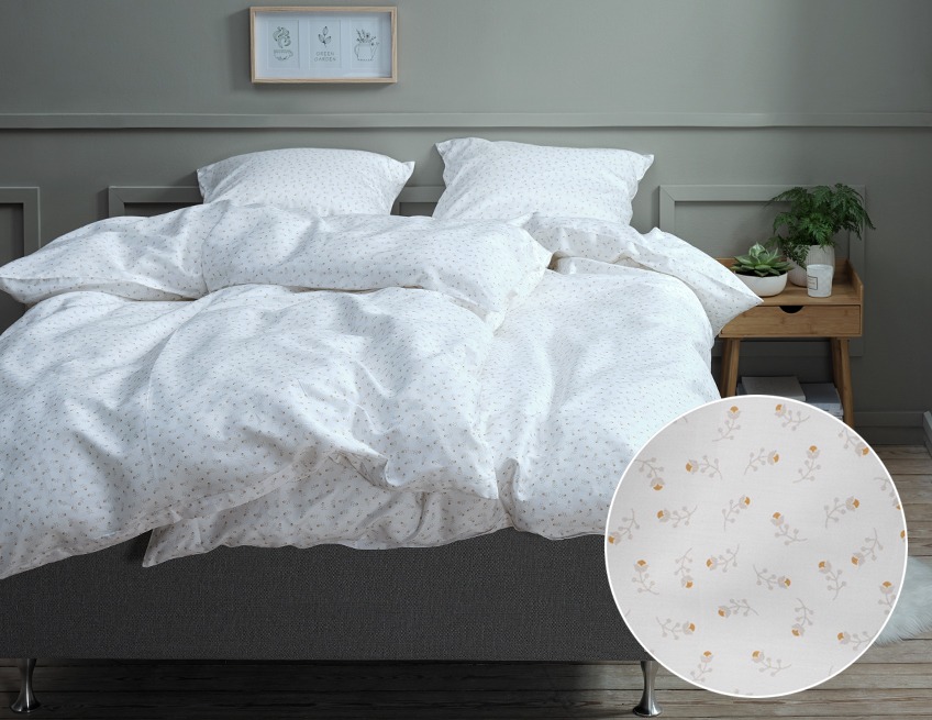Soveværelse med seng redt op med lyst, blomstret sengetøj