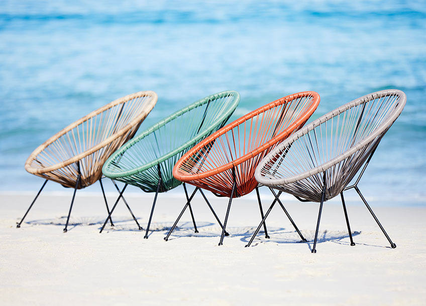 UBBERUP loungestole i sand, grøn, rød og grå Fire loungestole i forskellige farver på en strand