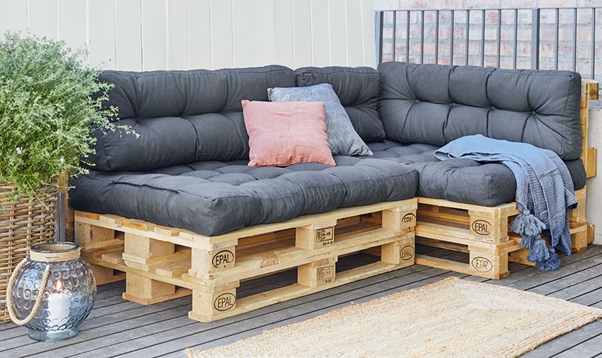Pallesofa med SKJERPE pallehynder Pallesofa med hynder og plaid på en terrasse