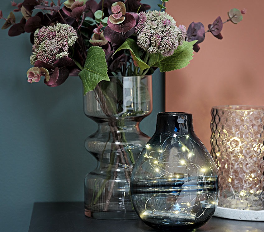 Samling af vaser med lyskæder og kunstige blomster