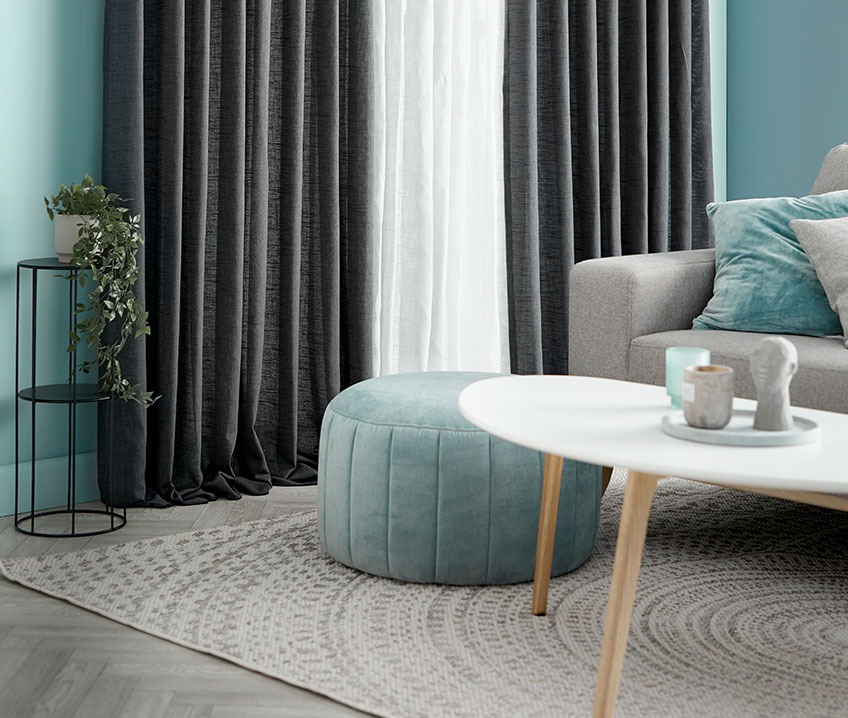 Stue med sofa, sofabord, puf og løst tæppe