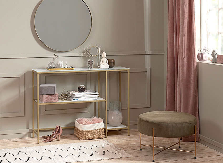 Stue med spejl med guldramme, puf og lille konsolbord